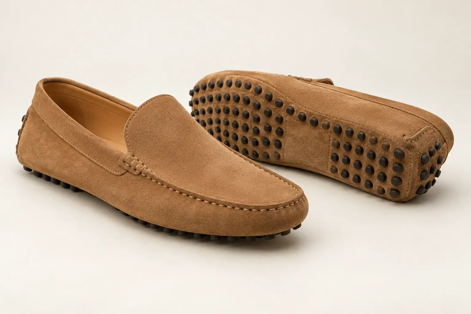 AI illustration of suede driving moccasins showing small rubber sole nubs continuing up the heel.